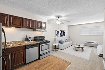 A modern kitchen with dark wood cabinets and stainless steel appliances. at Malvern Hill Apartment Homes, 66103, Kansas